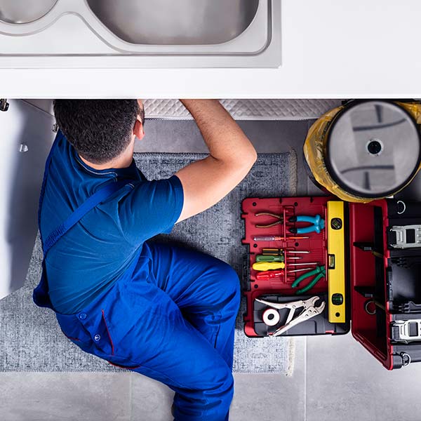 Plumber fitting a pipe of a sink